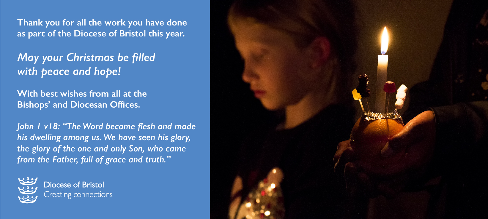 Christmas greeting - boy holding a Christingle in the dark